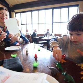 Mother and Child Playing with Toys at Restaurant