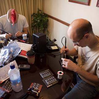 Two Men Working on Electronics at a Table