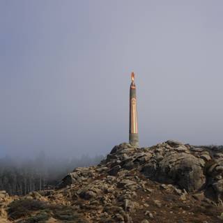 Towering Beacon amidst the Foggy Mountains