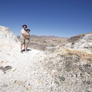 Father and son conquer rocky hill on desert adventure