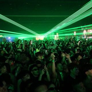 Green Laser Light Show Over Festival Dance Crowd