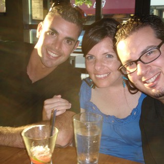 Three Friends Smiling Together at Restaurant Table