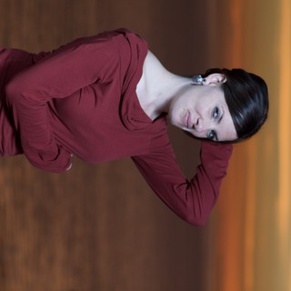 Woman in Red Poses Against Golden Sunset Sky