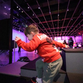 Child Dancing at Purple-Lit Baby Rave Museum Event