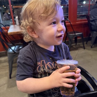 Young Child Enjoying a Drink at Restaurant