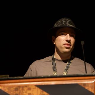 Hat-Wearing Speaker at the Podium