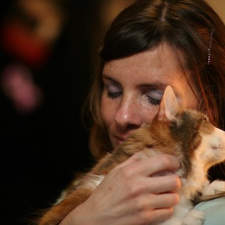 Tender Moment: Woman Nuzzles Ginger Kitten Lovingly
