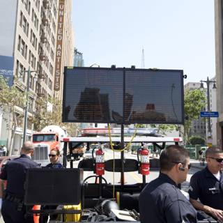 Police Officers Monitor Electronic Sign at May Day Rally