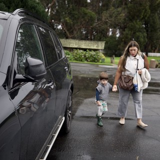 Mother and Child Walking to Car on Rainy Day