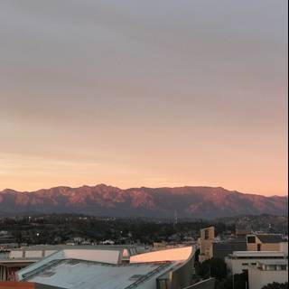 Sun setting over the urban mountains and buildings of LA