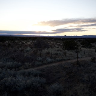 Desert Twilight Along a Fence-Lined Dirt Road
