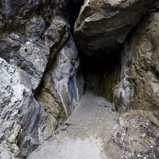 Dark Passage Into Ancient Rocky Cave Entrance