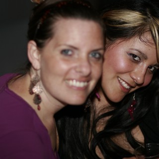 Two Smiling Women Posing Together at Night Event