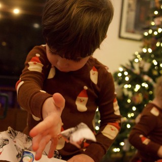 Child Opening Christmas Presents by the Tree