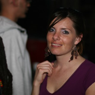 Smiling Woman at a Nighttime Social Gathering
