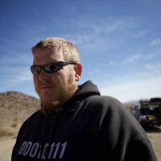 Man in a Hoodie and Sunglasses Embracing the Desert