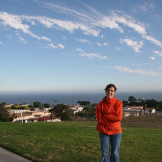 Woman Smiling on Hilltop Overlooking California Coastal Town