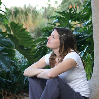 Contemplative Woman Resting Beside Tropical Foliage
