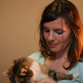 Tender Moment: Woman Cradling Sleeping Kitten