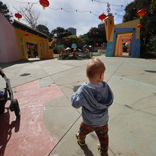 Young Child Explores Colorful Festival Plaza