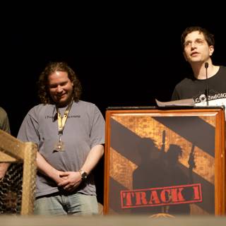 Three men behind podium with microphone