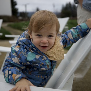 Joyful Toddler Playing on White Fence at Playground