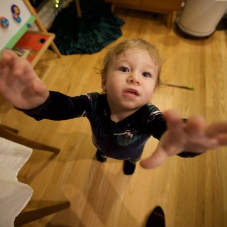 Toddler Reaching Up Toward Camera on Christmas Morning