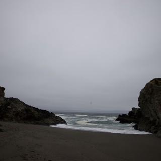 Moody Coastal Cove Between Ancient Rocky Sentinels