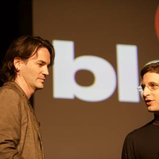 Two Men Presenting in Front of a Screen