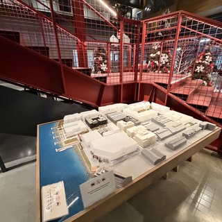 Architectural Model Display in Red Industrial Gallery Space