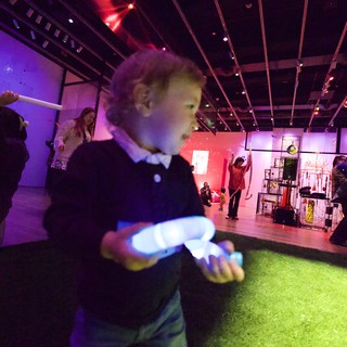Child Dancing with Glowing Toy at Baby Rave Event