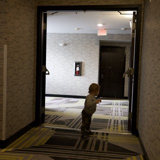 Toddler Exploring Modern Hotel Hallway at Night