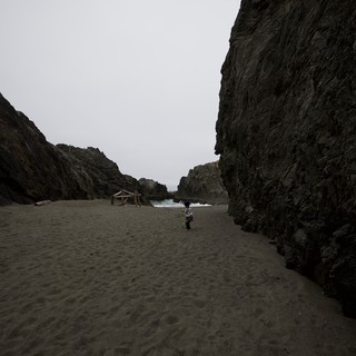 Child Exploring a Dramatic Coastal Cove at Low Tide