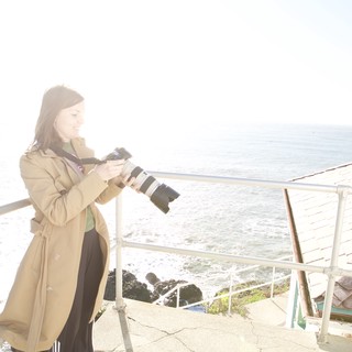 Photographer Capturing Coastal Scenes with Professional Camera