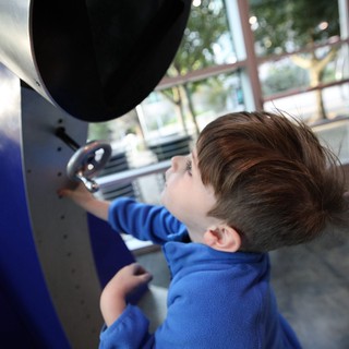 Young Boy Exploring Interactive Exhibit at Science Center