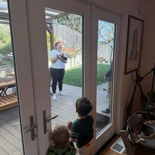 Mother and Children Sharing a Moment Through Glass Door