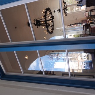 Blue-Framed Window View into Mediterranean Restaurant Interior