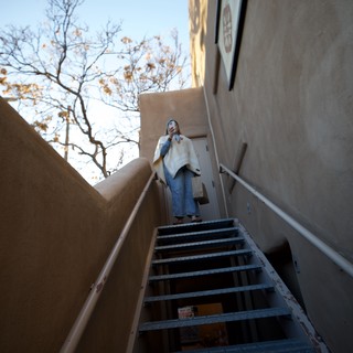 Upward Perspective: Woman at Top of Metal Staircase