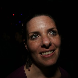 Smiling Woman in Dimly Lit Event Venue