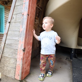 Young Boy Exploring Vintage Doorway with Curiosity
