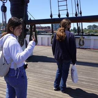 Tourists Exploring Historic Sailing Ship Deck