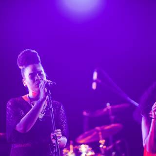 Two Women Rocking the Stage with Purple Lights