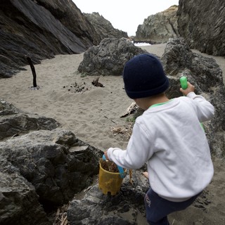 Young Explorer Navigating Rocky Beach Cove Adventure