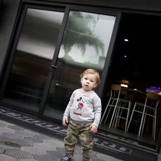 Young Child Outside Modern Storefront in SLO
