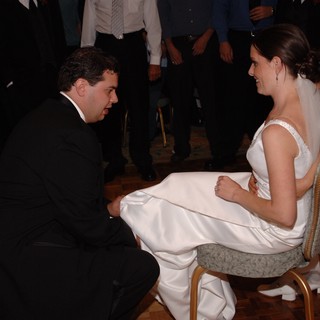 Groom Removes Garter from Smiling Bride at Reception