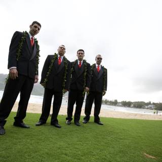 Four Men in Suits Standing on Grassy Shore