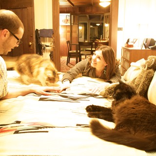 Couple Relaxing on Bed with Their Cats