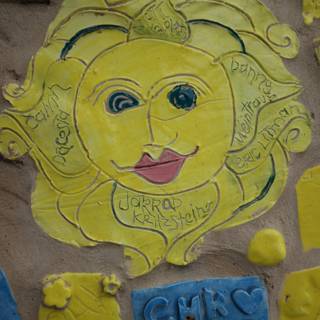 Yellow Sun Face Mural on Building Wall