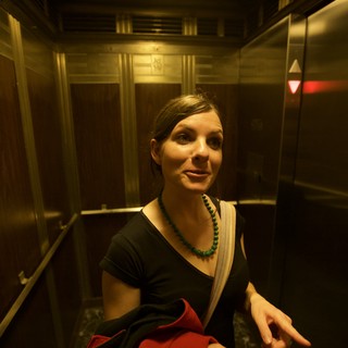 Woman Smiling in Vintage Elevator at Night