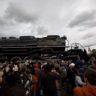 Crowd Gathers Around Historic Steam Locomotive Under Dramatic Sky